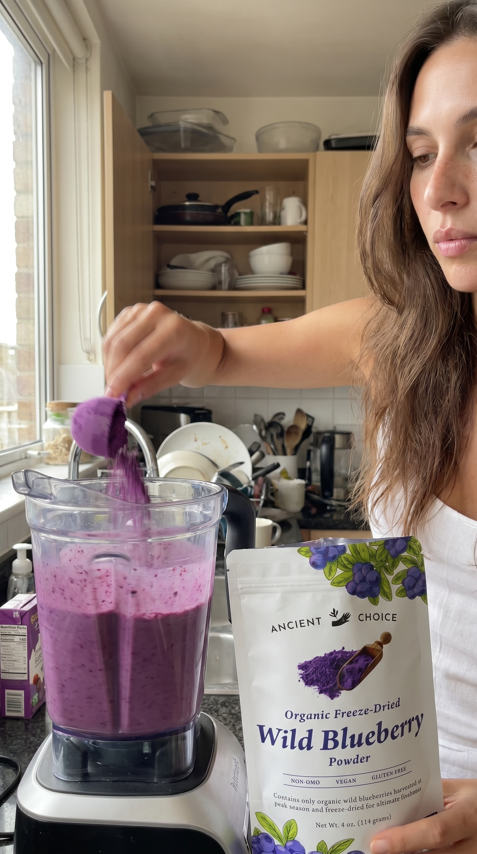 Creator adding blueberry powder to a blender